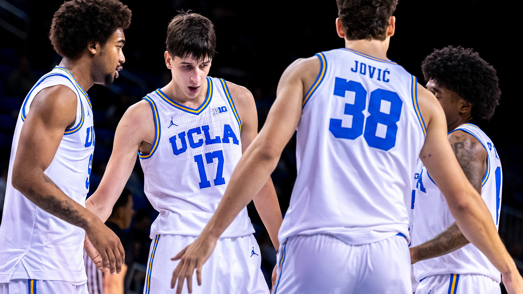 Brandon Williams and Nikola Kustrurica huddle their teammates together on the court.