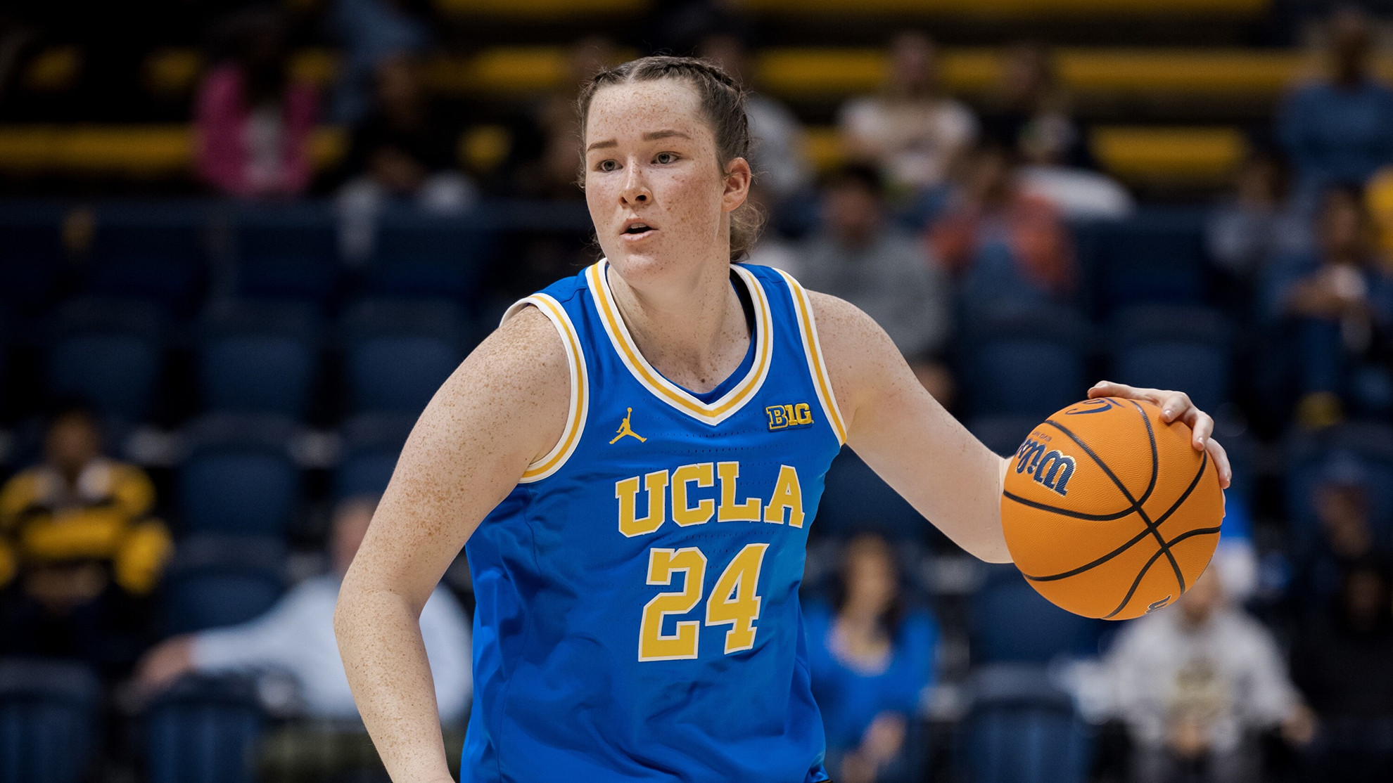 Addy Brown, wearing a blue UCLA jersey, dribbles a basketball during the Bruins' preseason exhibition at Cal. The ball is chest height, and Brown looks for her teammates out of frame.