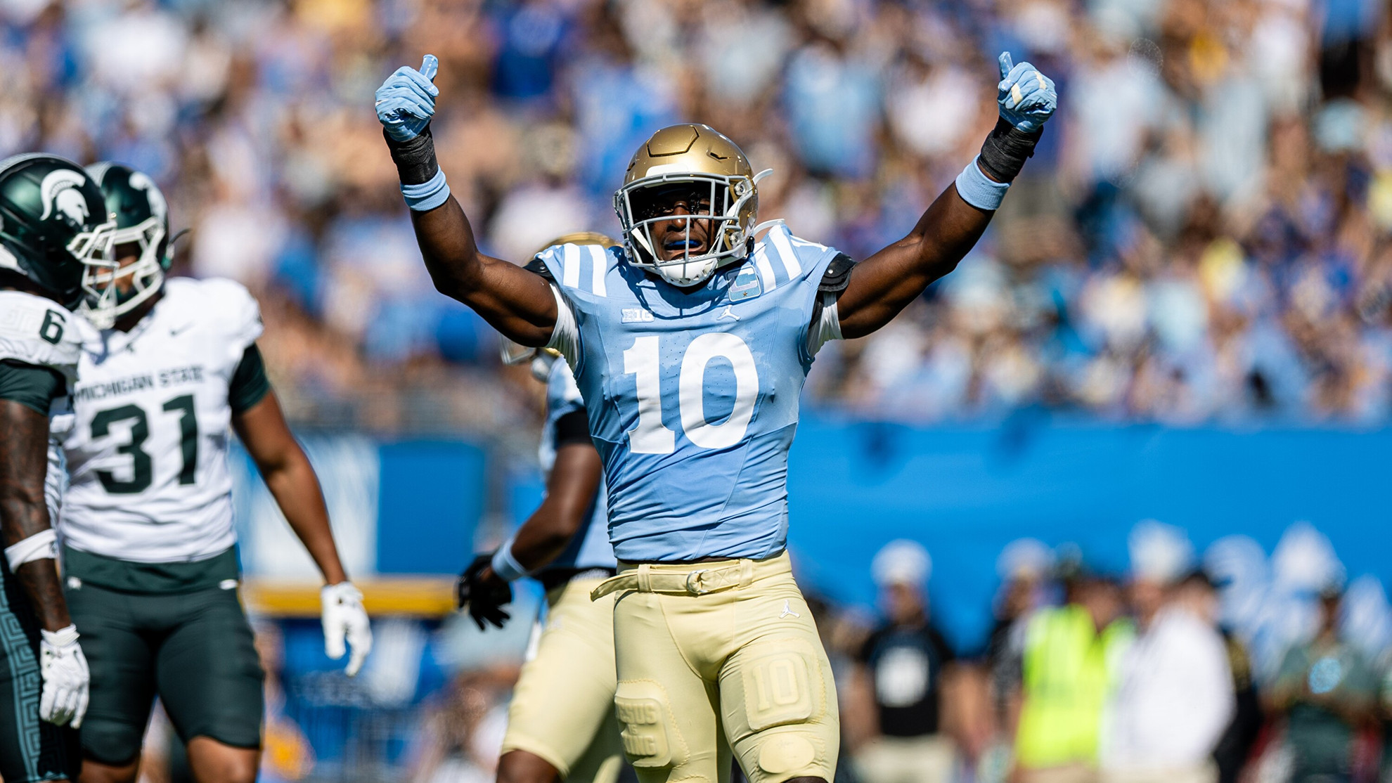 Linebacker Sammy Omosigho holds up both hands in celebration during UCLA's home game against Michigan State.