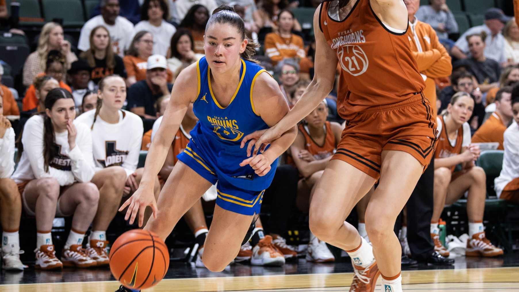 Junior point guard Elina Aarnisalo drives baseline during UCLA's exhibition game against Texas. Aarnisalo makes contact with a Longhorn defender on her left hip as she pushes the basketball towards the floor with her right hand.