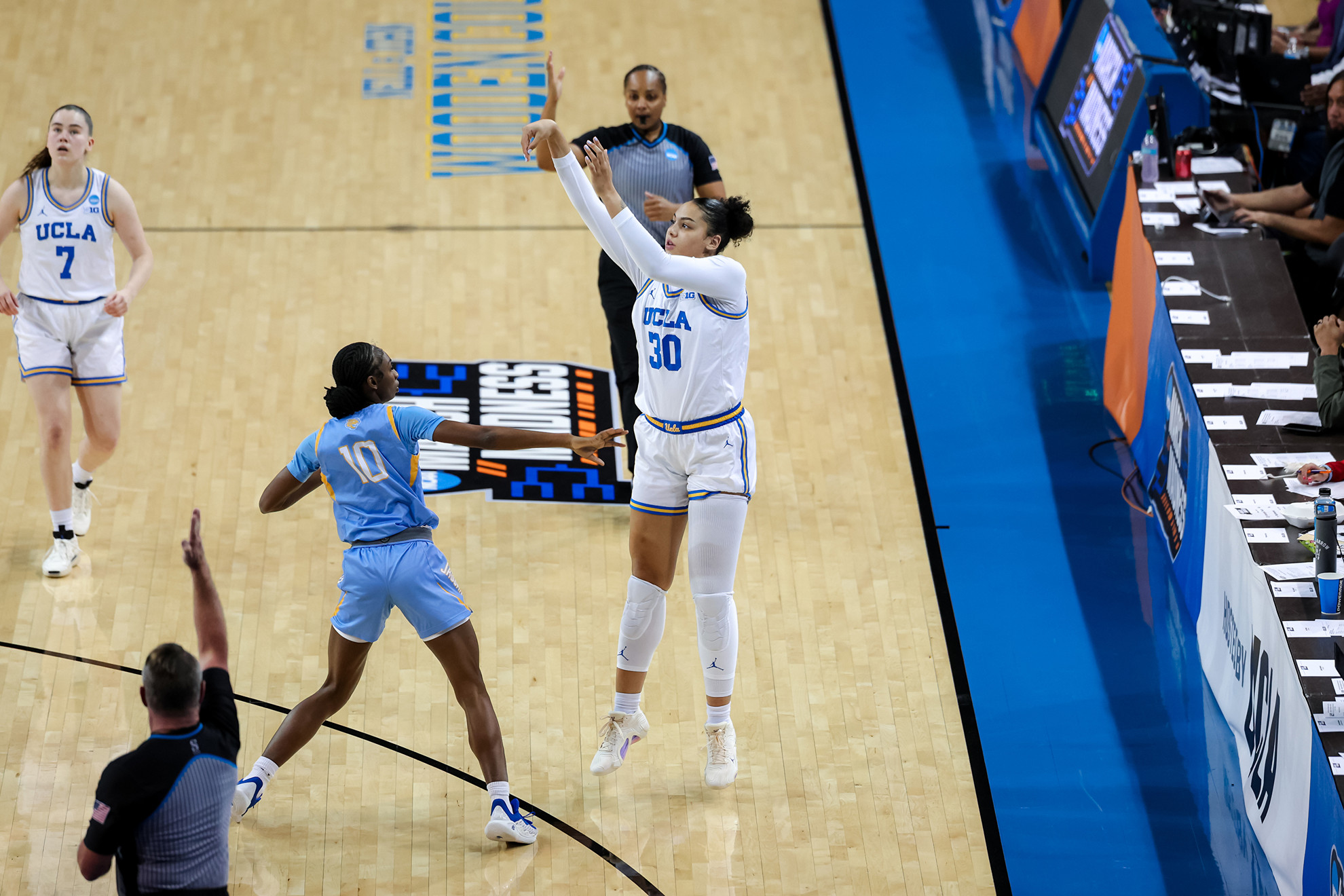 Timea Gardiner attempts a three-pointer from the right wing. Teammate Elina Aarnisalo watches from the top of the arc, and a defender from Southern University stands nearby after a late close out.