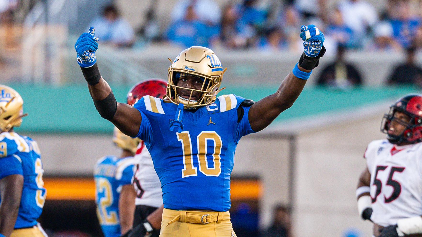 Sammy Omosigho raises his arms in celebration of a play on defense during UCLA's game versus San Diego State