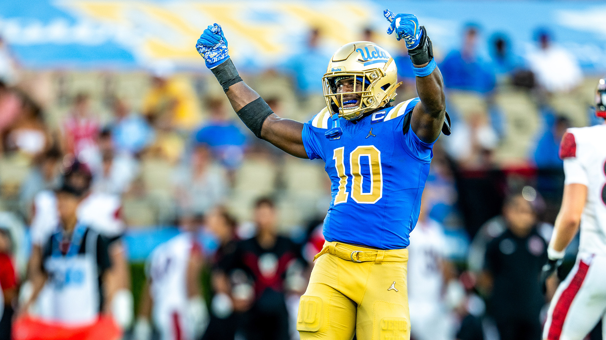 Linebacker Sammy Omosigho raises his arms to celebrate a play